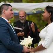 A bride and groom are holding hands during their wedding ceremony.
