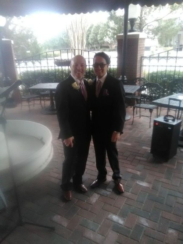 Two men in suits are standing next to each other on a patio.