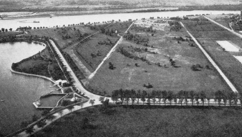 An aerial view of a park with a river in the background
