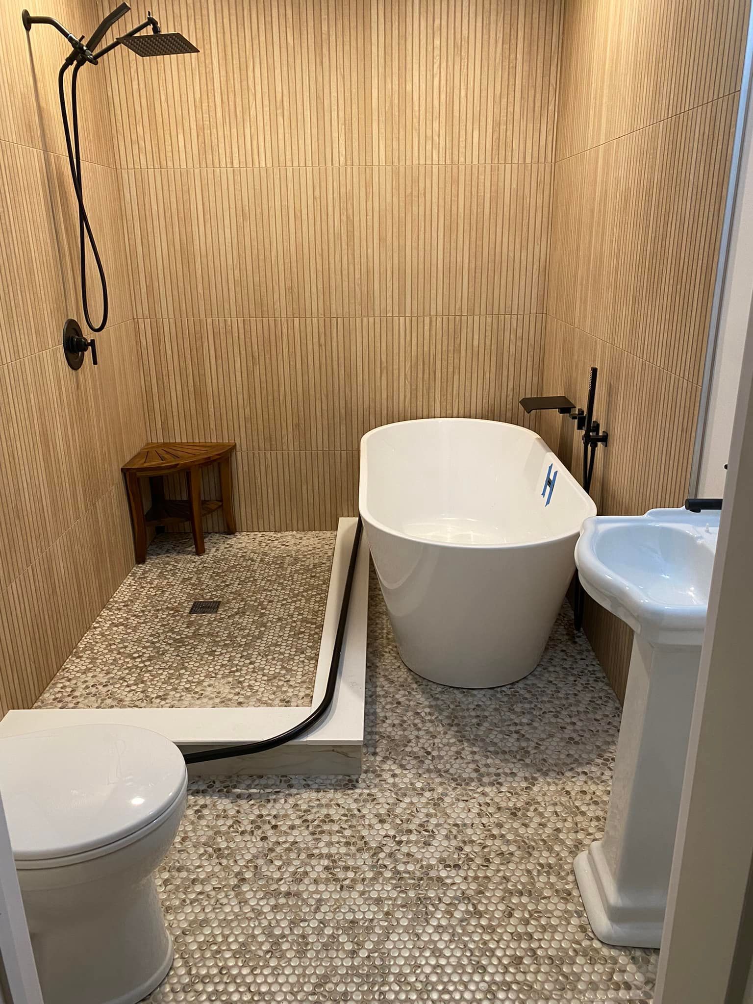 A bathroom with a bathtub , toilet , sink and shower.