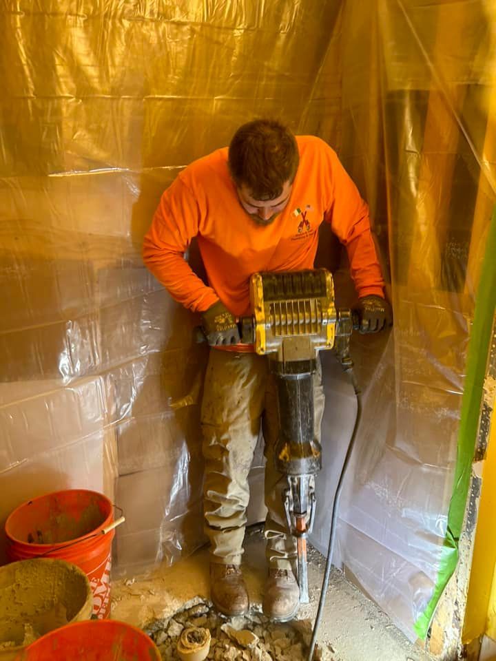 A man is using a hammer to break a hole in the ground.