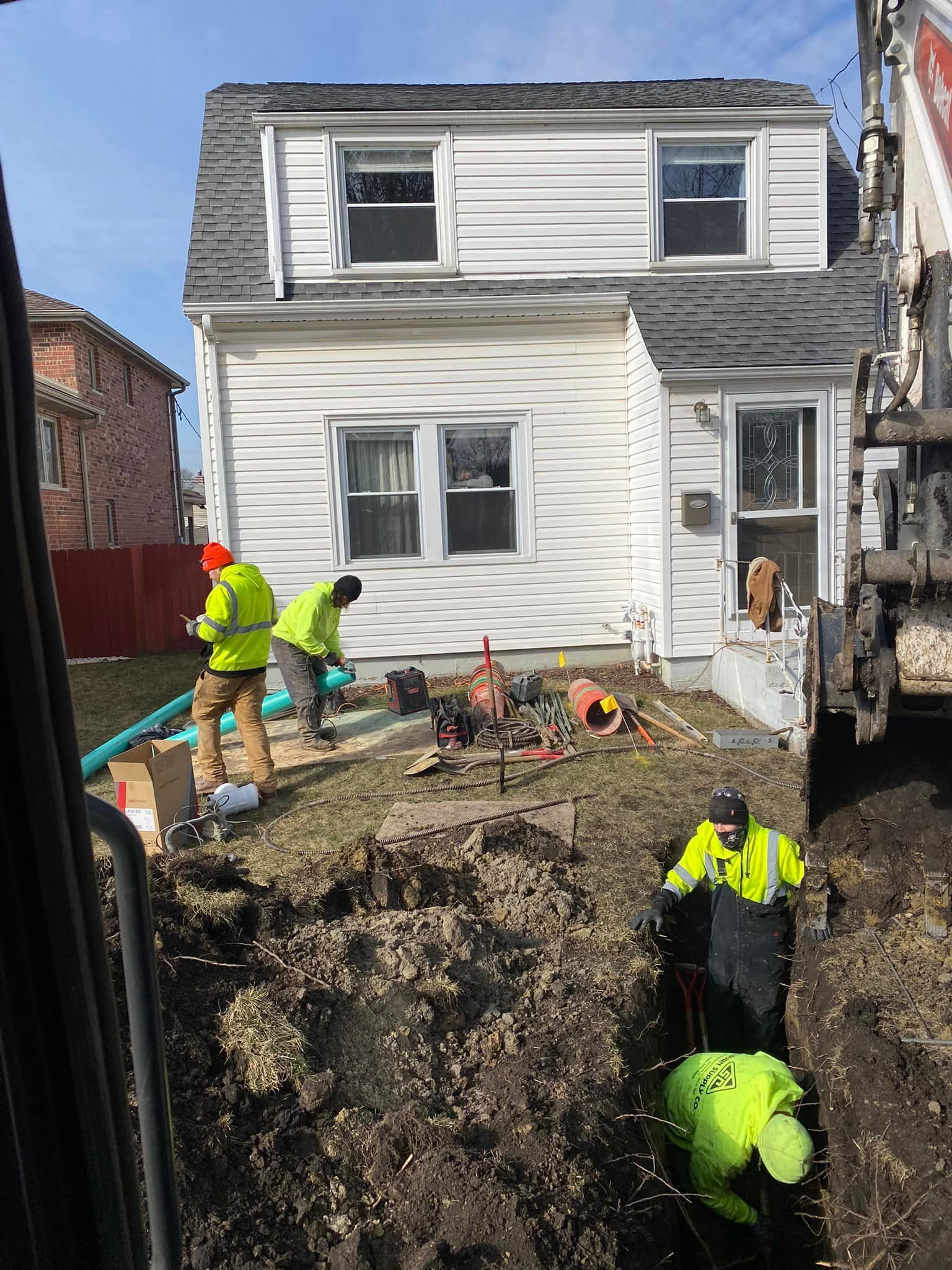 A group of construction workers are working in front of a house.
