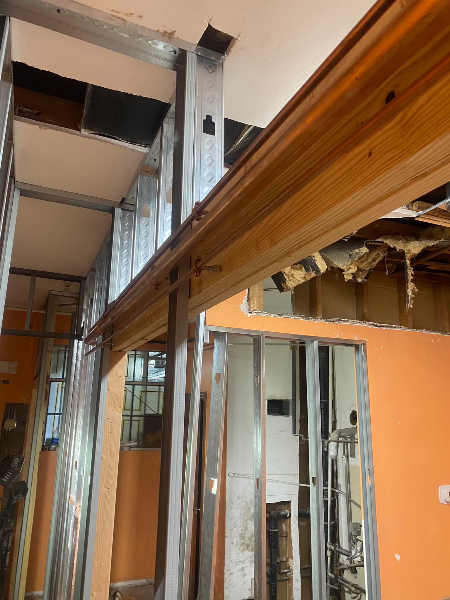 A building under construction with a ladder hanging from the ceiling.