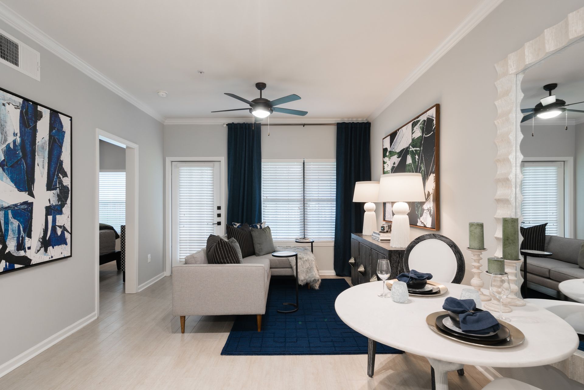 A modern living room with blue accents and light wood floors.