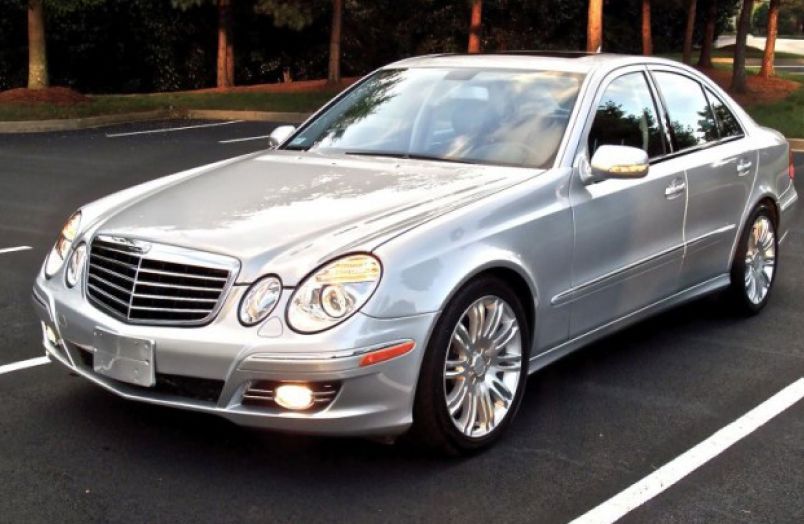 A silver Mercedes-Benz E-Class sedan parked in an asphalt lot. | Allstar Automotive
