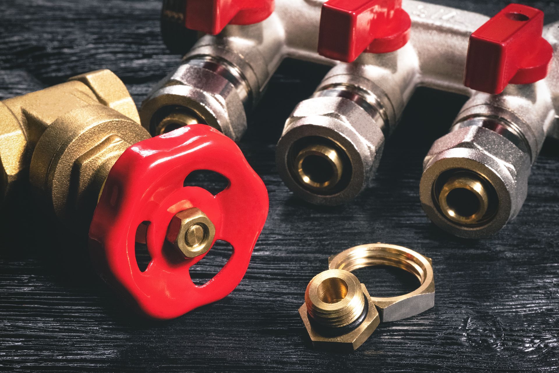 A pile of brass plumbing valves and fittings with various shapes and sizes.