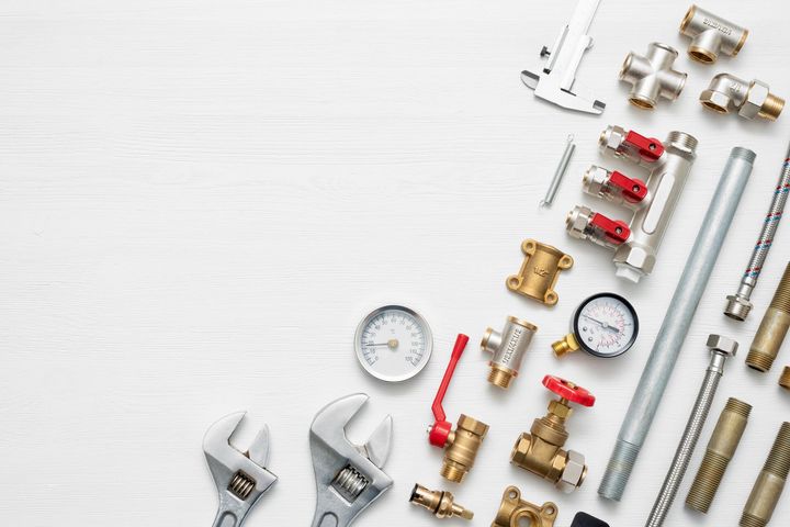 Plumbing parts are flat-laid on a white background, showcasing water system accessories.