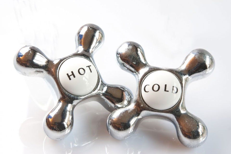 A pair of hot and cold faucet handles on a white surface