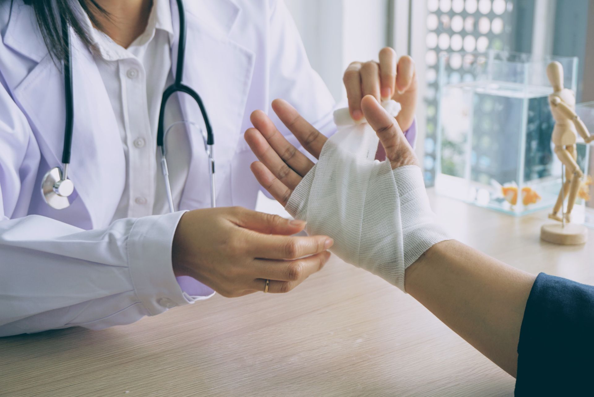 Doctor wrapping a patient's hand with a bandage in a clinic.