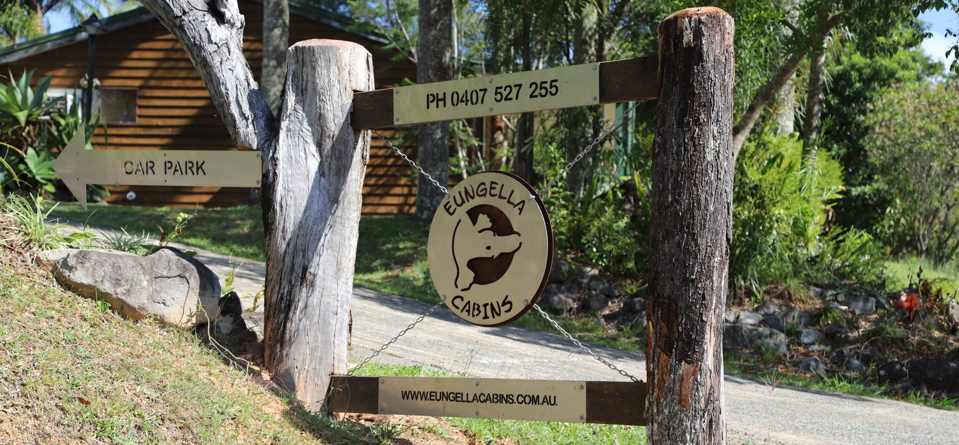 Wooden signpost with directions to a cabin carpark