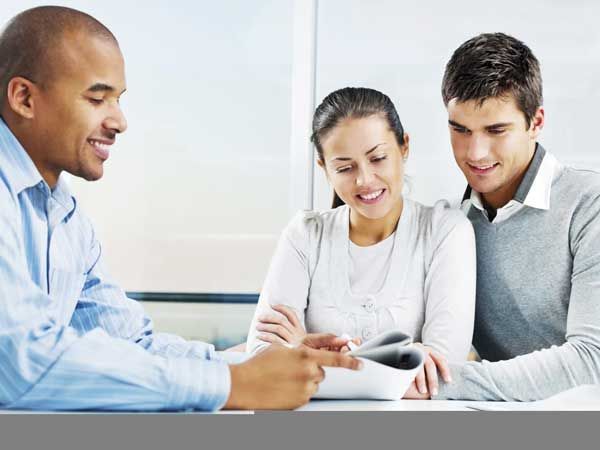 A man is sitting at a table with a woman and a man.