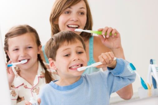 Mother and children brushing teeth - Oral Health in Schererville, IN