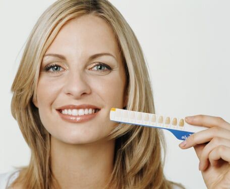 Woman holding up tooth whitening chart - Oral Health in Schererville, IN