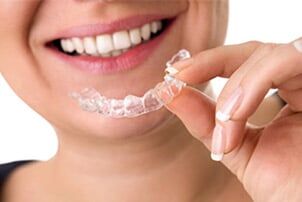 Smiling Female Holding Invisible Teeth Braces - general dentistry in Schererville, IN