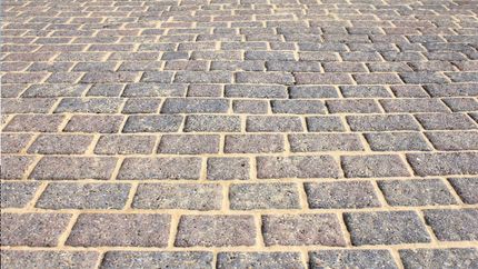 A close up of a cobblestone driveway with a brick pattern.