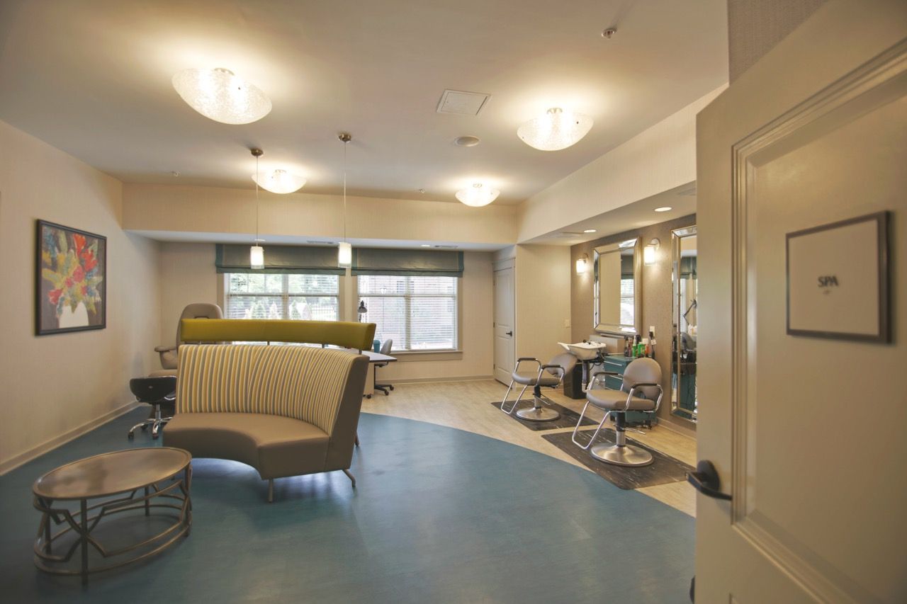 Interior of a resident community spa/salon with styling chairs, mirrors, and wash stations.
