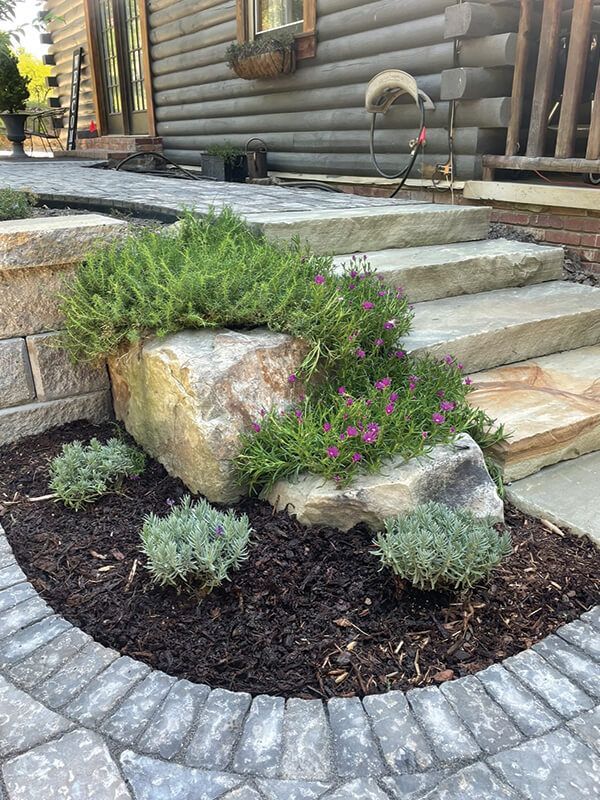 There is a large rock in the middle of the garden.