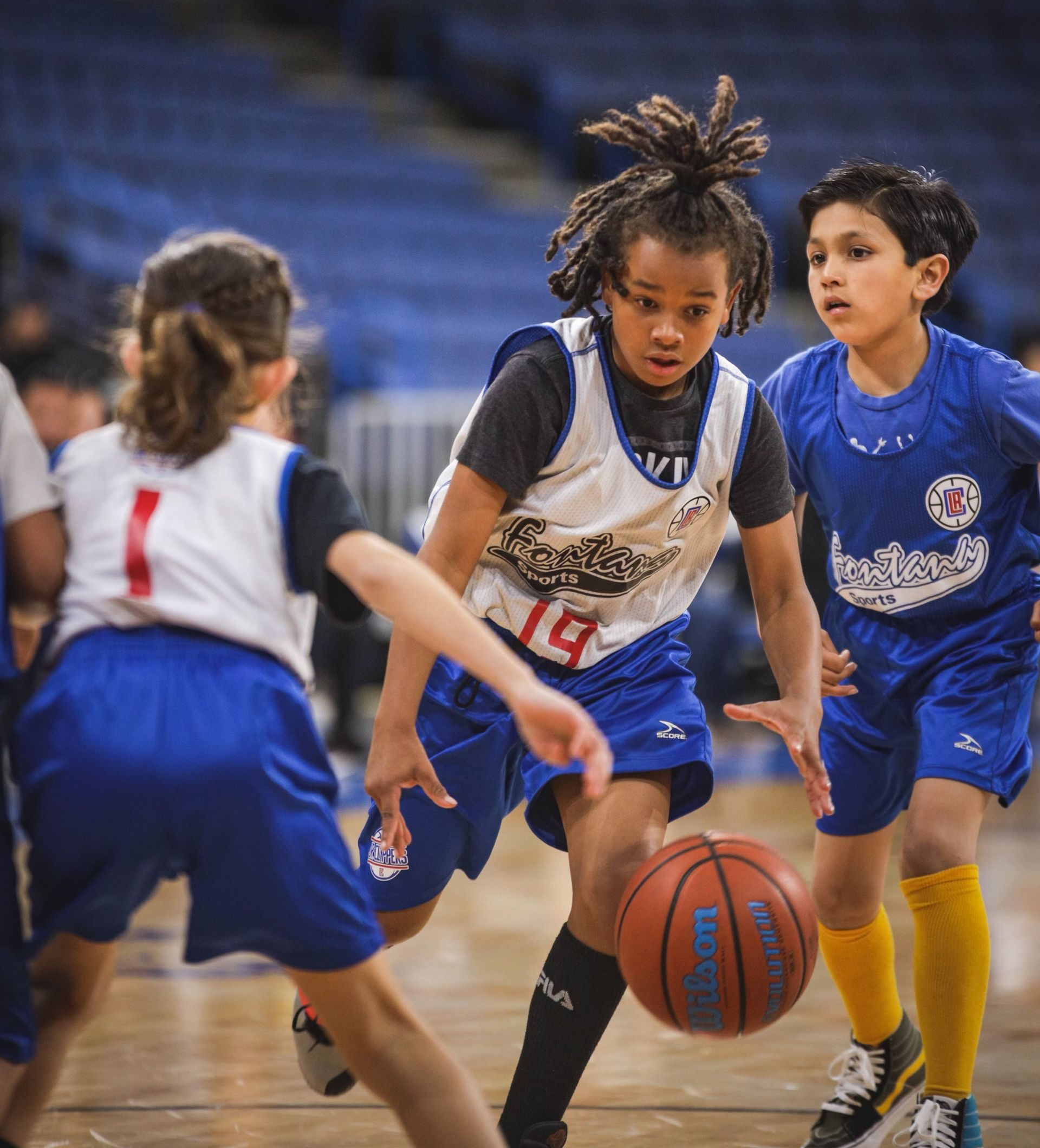 Baseball player sliding into home plate, catcher in front. Blue and gold uniforms, action shot.