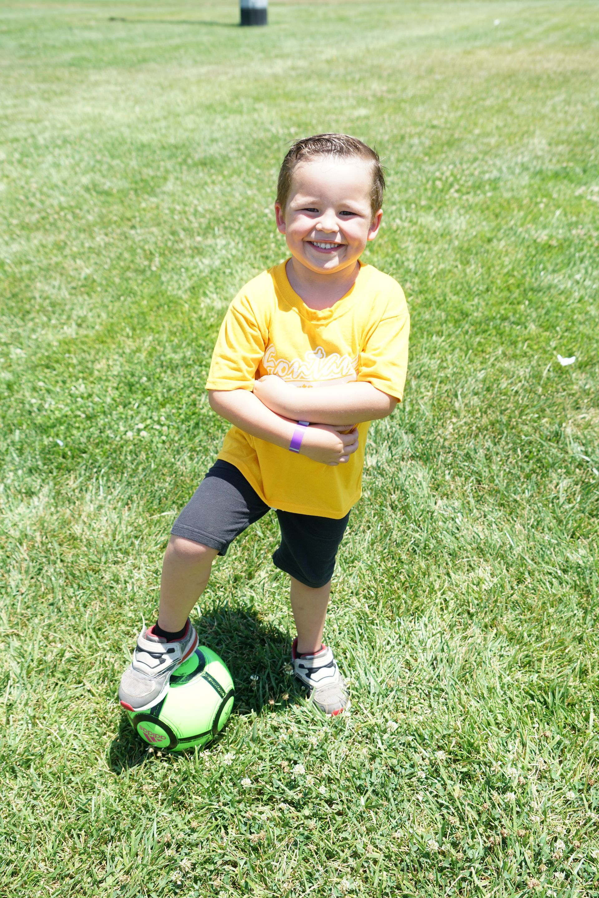 Baseball player sliding into home plate, catcher in front. Blue and gold uniforms, action shot.