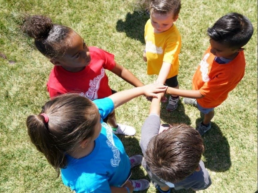 Baseball player sliding into base as another player attempts to catch the ball.