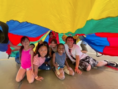Baseball player sliding into home plate, catcher in front. Blue and gold uniforms, action shot.