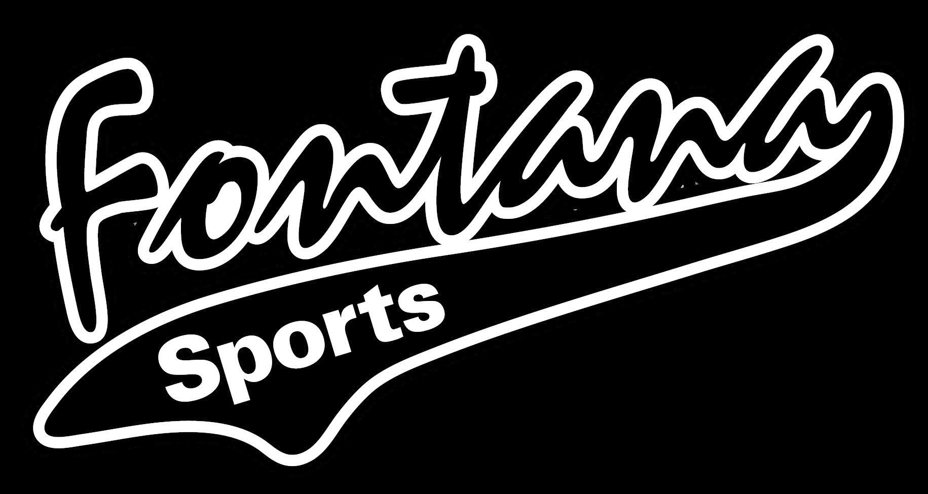 Football coach with arms crossed, standing on a football field. He wears a navy polo shirt and gray pants.