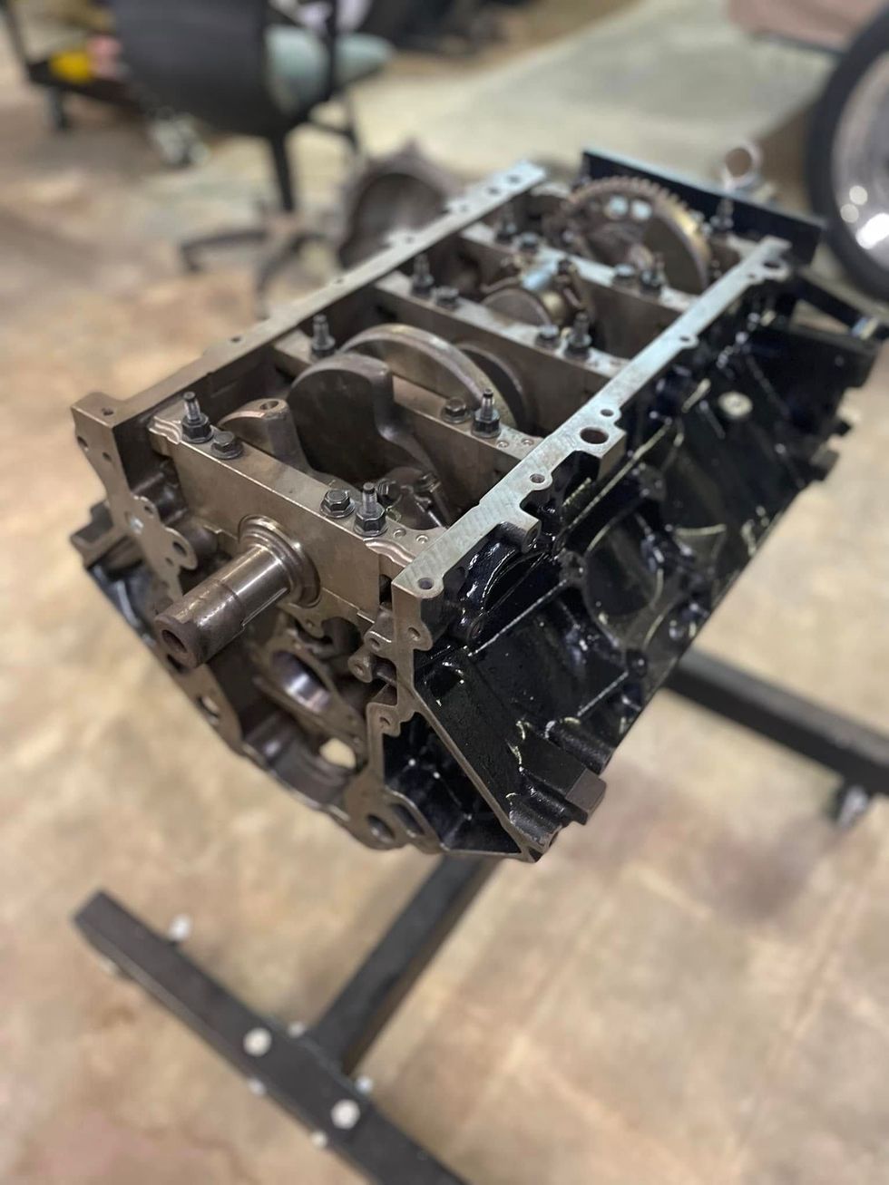 Black engine block on a black engine stand, showing crankshaft, rods, and pistons built in house by classic hotrods. this engine has many perofrmance upgrades.