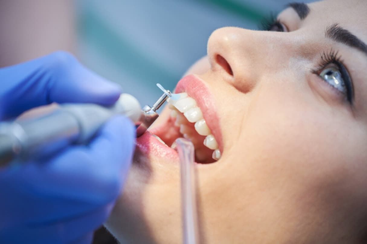 A Woman Is Getting Her Teeth Examined By A Dentist — Central Coast Denture Clinic Erina In Erina, NSW