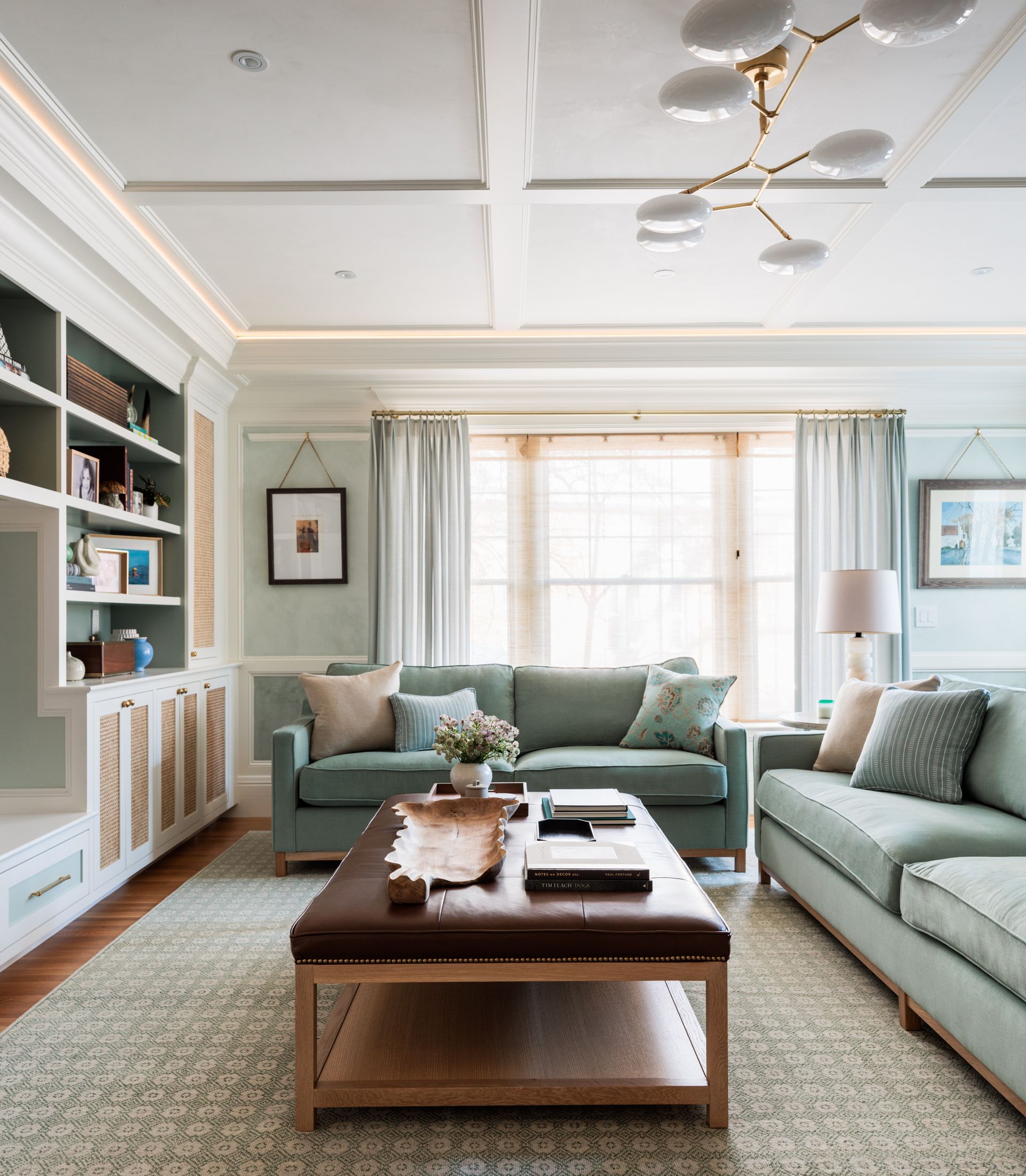 A living room with two couches and a coffee table, light and airy drapers and sheers