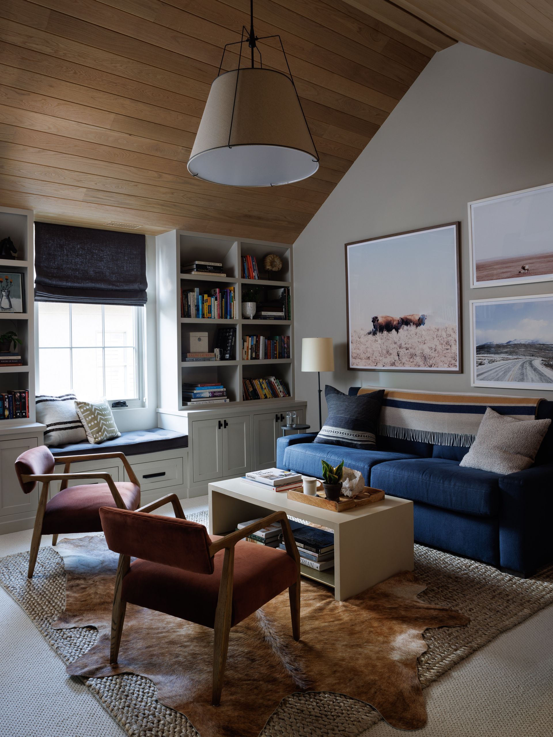 A living room with a blue couch and two chairs