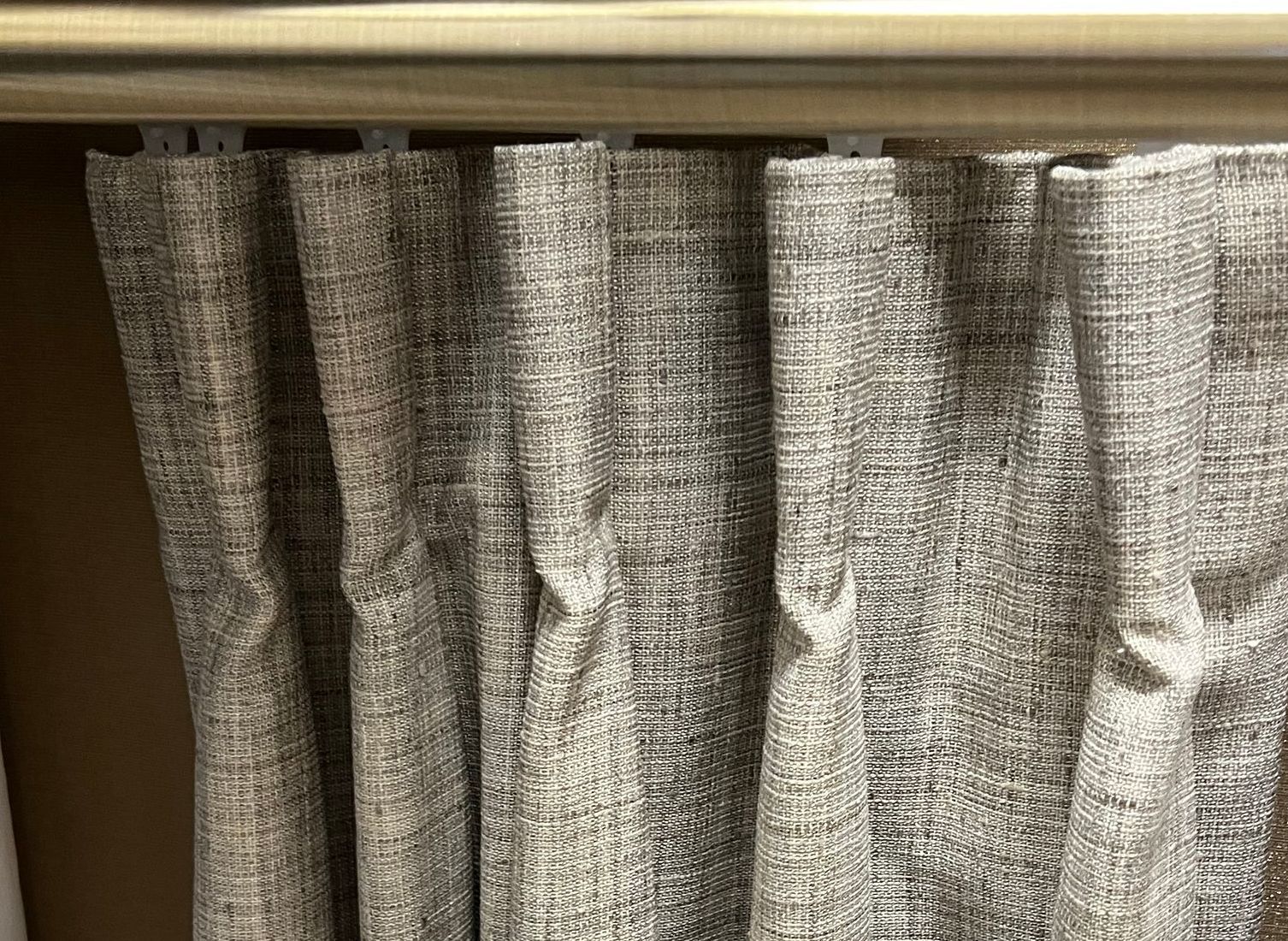 Light brown color Butterfly Pleat blinds hanging on the curtain rod