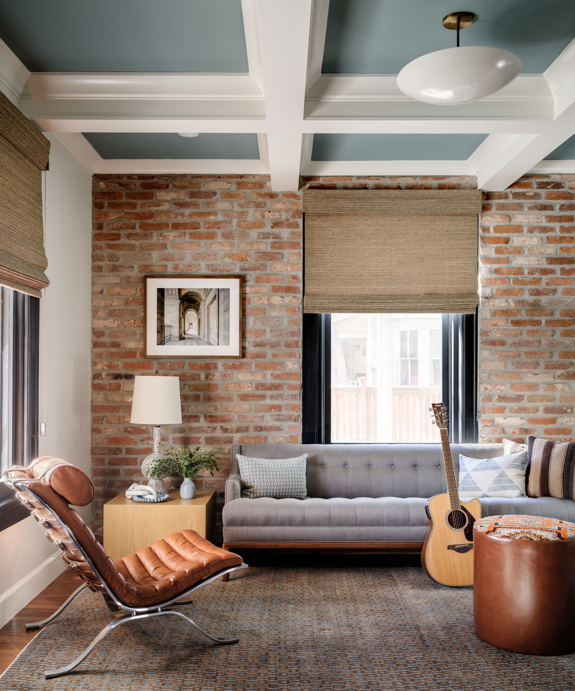 A living room with a couch a chair and a guitar