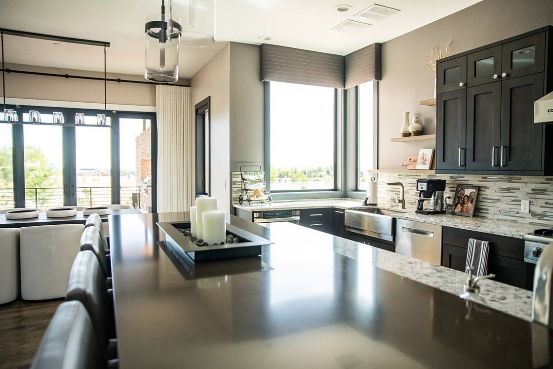 A kitchen with a large island and a lot of windows.