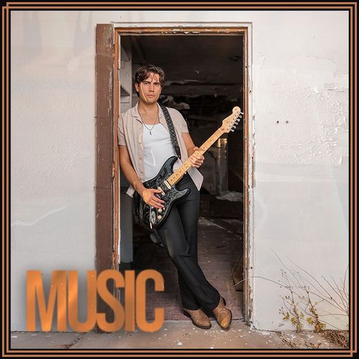 A man standing in a doorway holding a guitar with the word music above him
