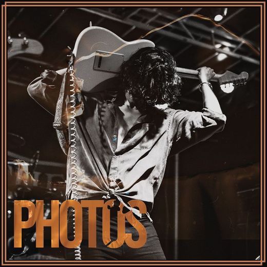 A photo of a man holding a guitar with the words photos above him