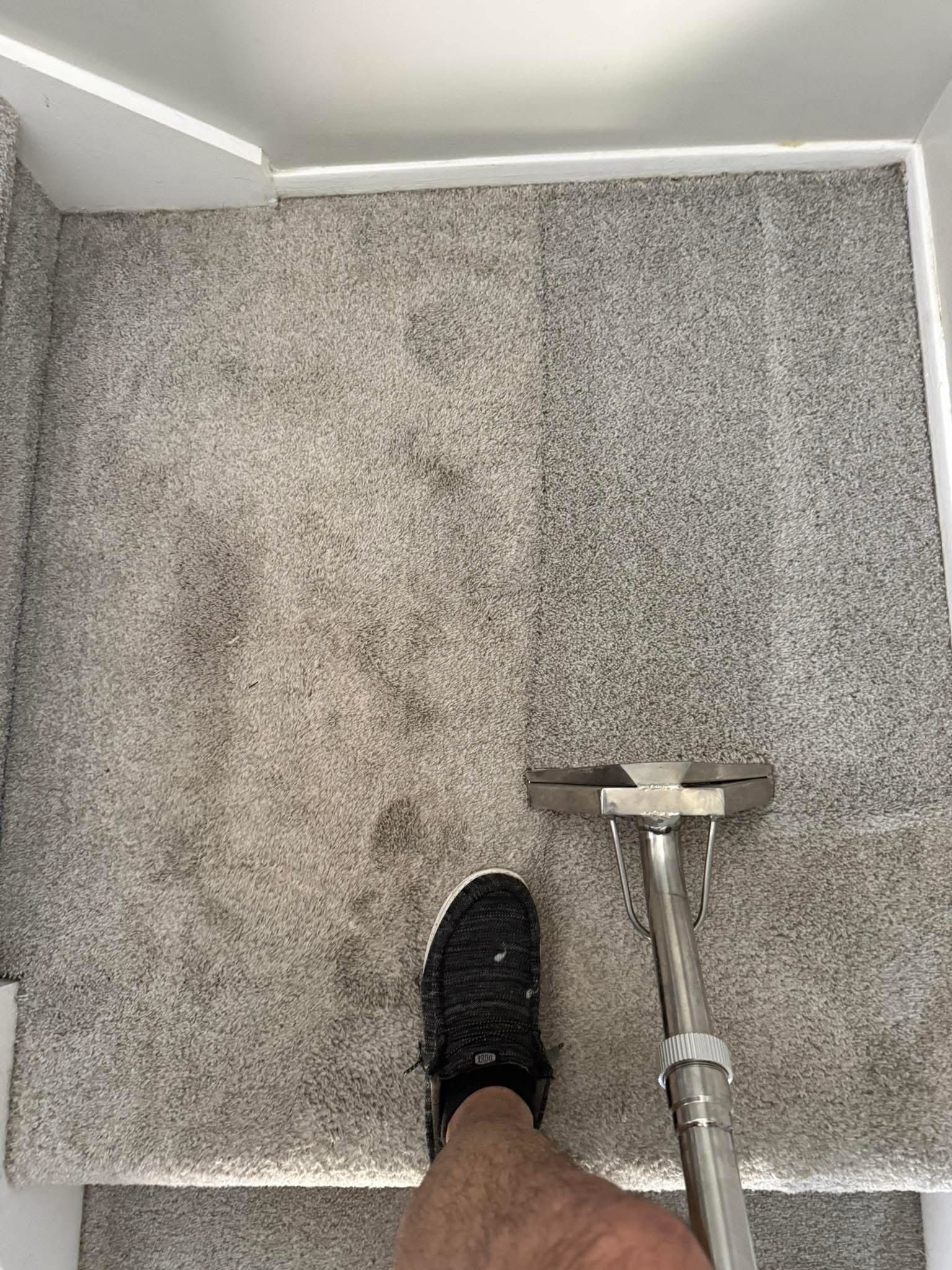 A man is using a vacuum cleaner to clean a hallway