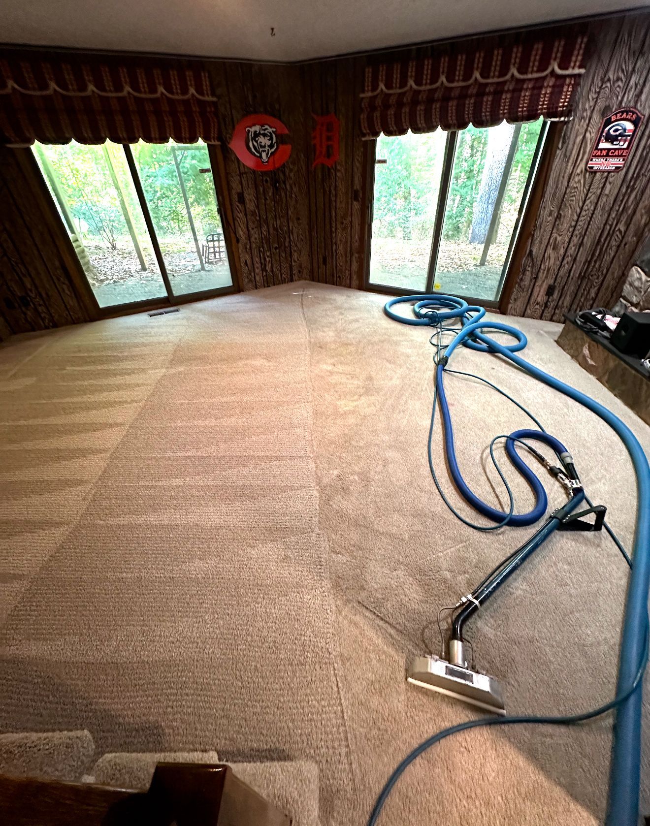 A vacuum cleaner is sitting on top of a carpeted floor in a living room.
