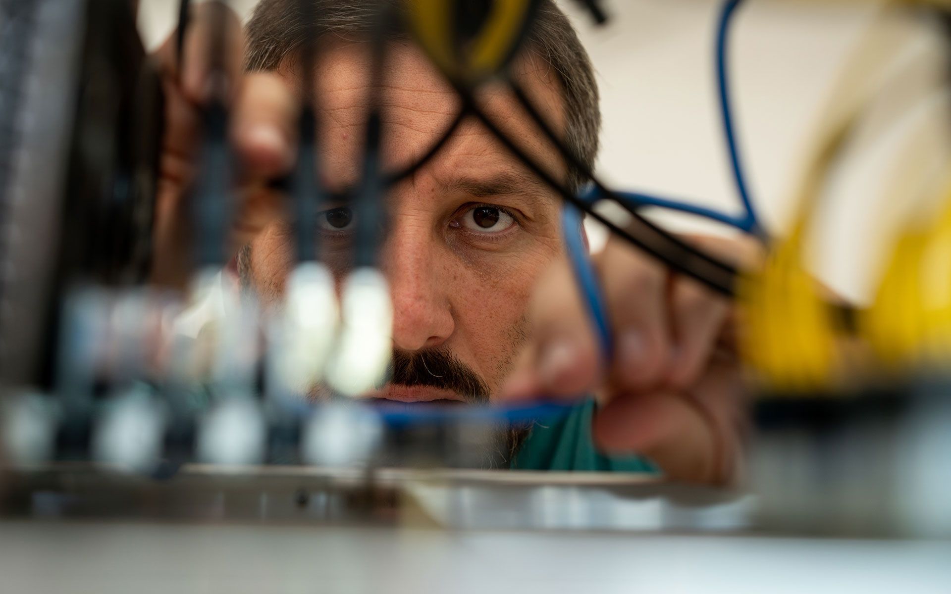 A man with a mustache is working on a computer.