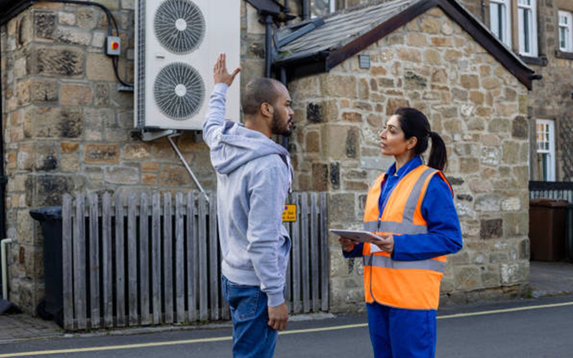 A man and a woman are standing next to each other in front of a building.