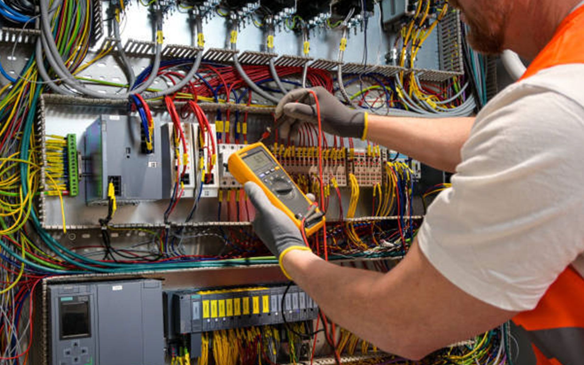 A large air compressor is sitting next to a large tank in a warehouse.