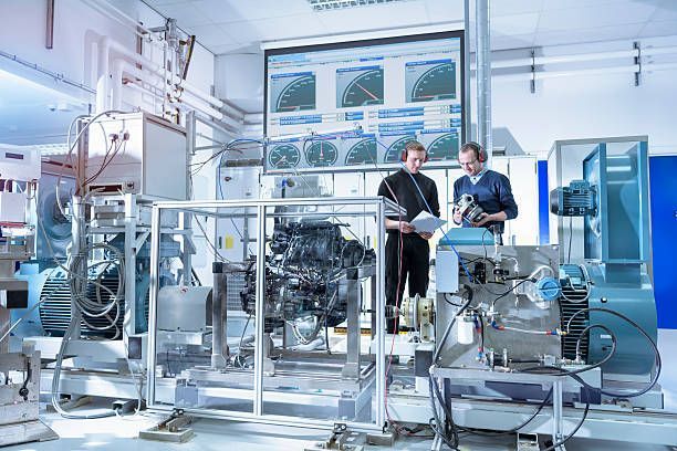 Two men are working on a machine in a factory.