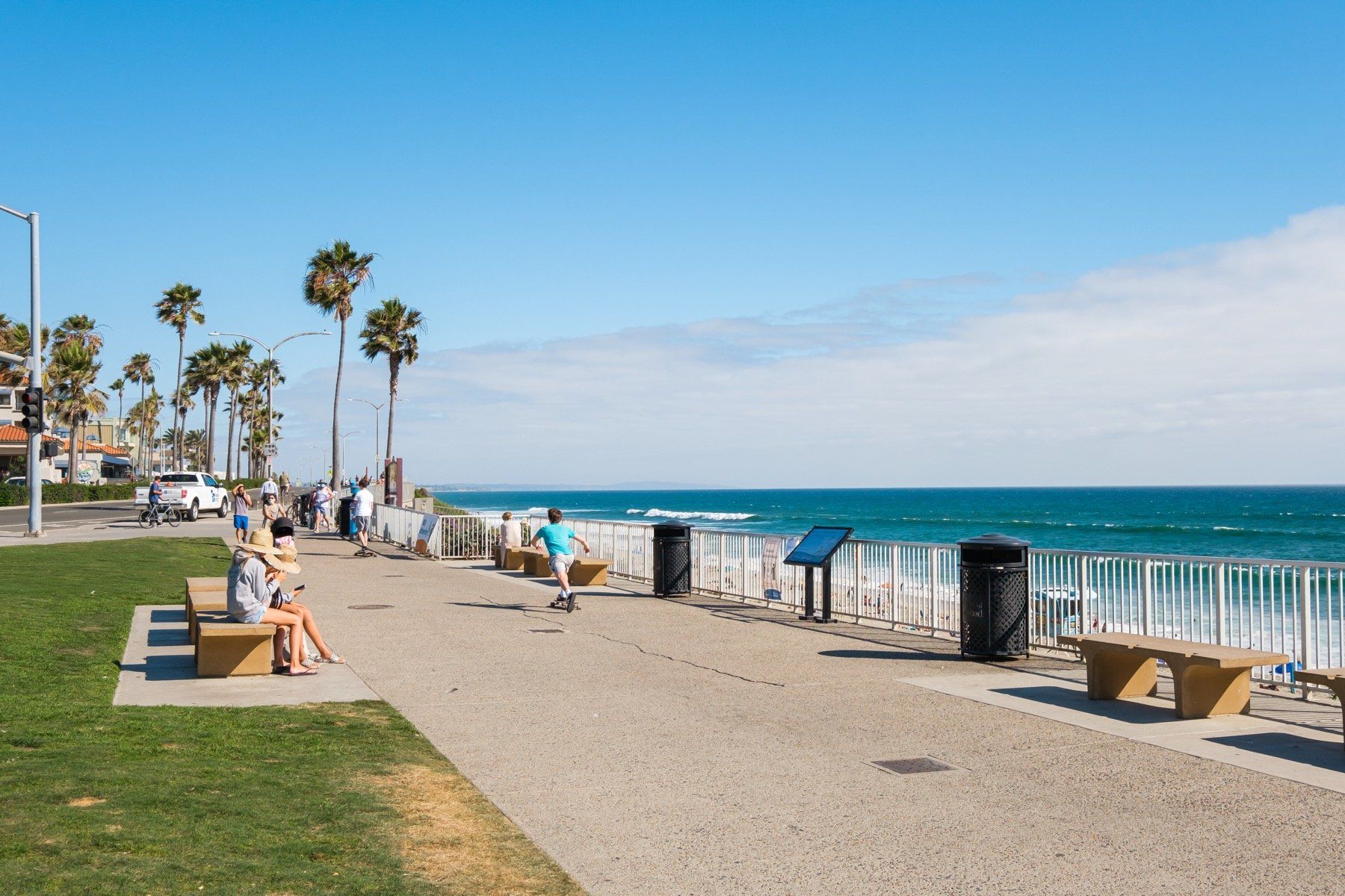 A group of people are sitting on benches on a beach near the ocean.