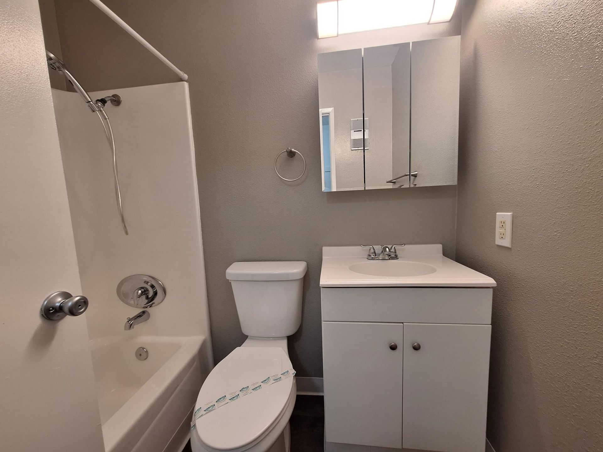 A bathroom with a toilet , sink , bathtub and shower.