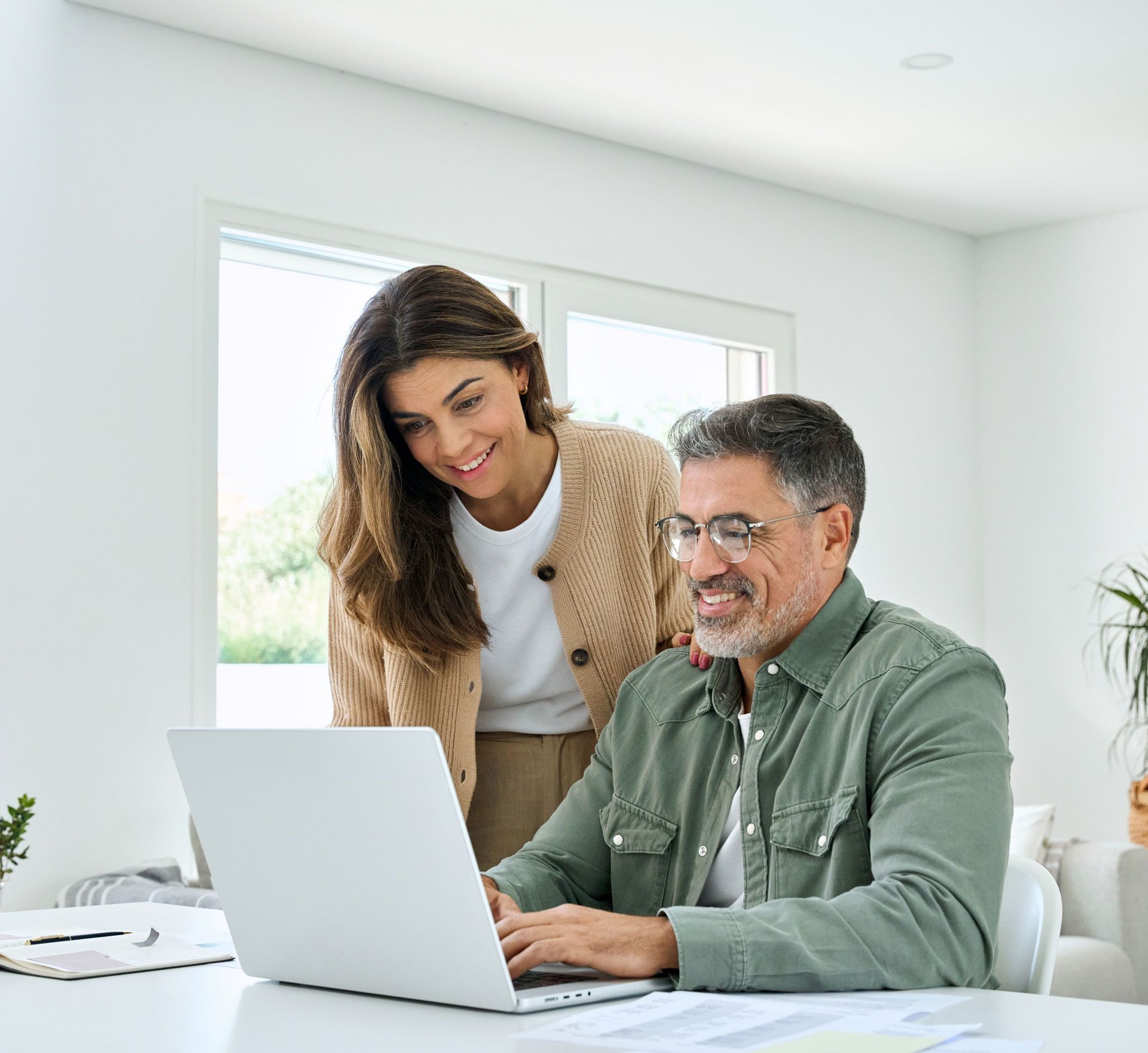A man and a woman are looking at a laptop computer.