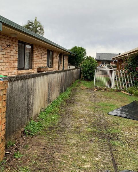 A Dirt Road Leading to A Brick House with A Fence — Northern Rivers Demolition & Asbestos in Lismore, NSW