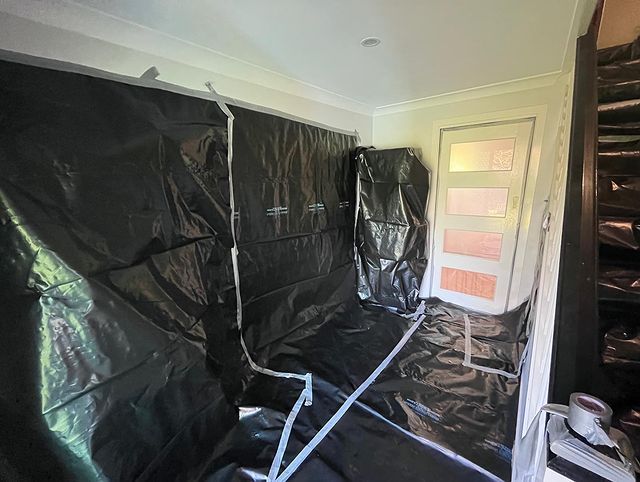 A Room with A Door and A Wall Covered in Black Plastic — Northern Rivers Demolition & Asbestos in Ballina, NSW