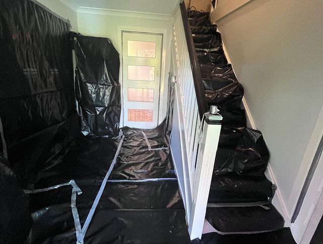 A Hallway with Stairs Covered in Black Plastic — Northern Rivers Demolition & Asbestos in Lismore, NSW