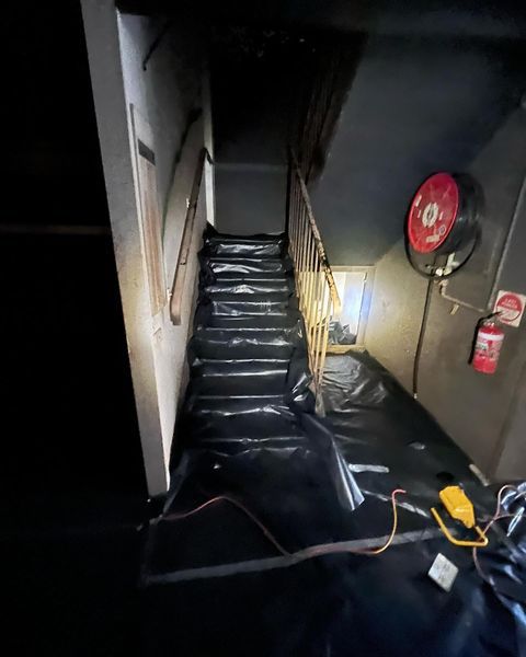 A Dark Room with Stairs and A Fire Extinguisher on The Wall — Northern Rivers Demolition & Asbestos in Casino, NSW