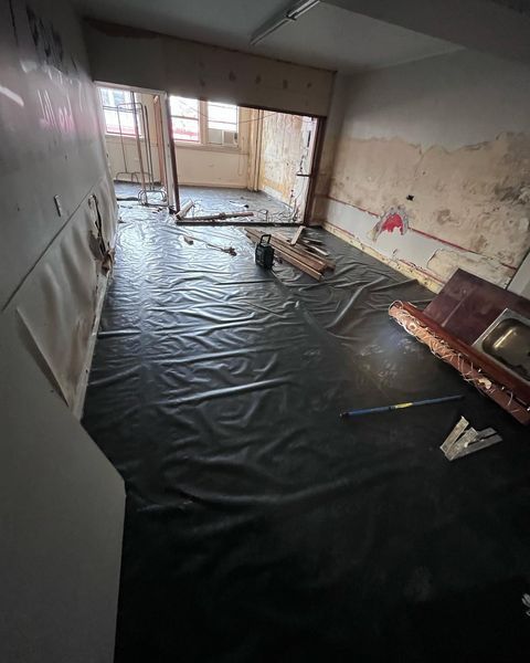 A Room with A Black Tarp on The Floor and A Mop on The Floor — Northern Rivers Demolition & Asbestos in Casino, NSW