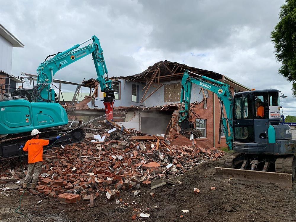 A Large Building Is Being Demolished by Two Excavators — Northern Rivers Demolition & Asbestos in Casino, NSW